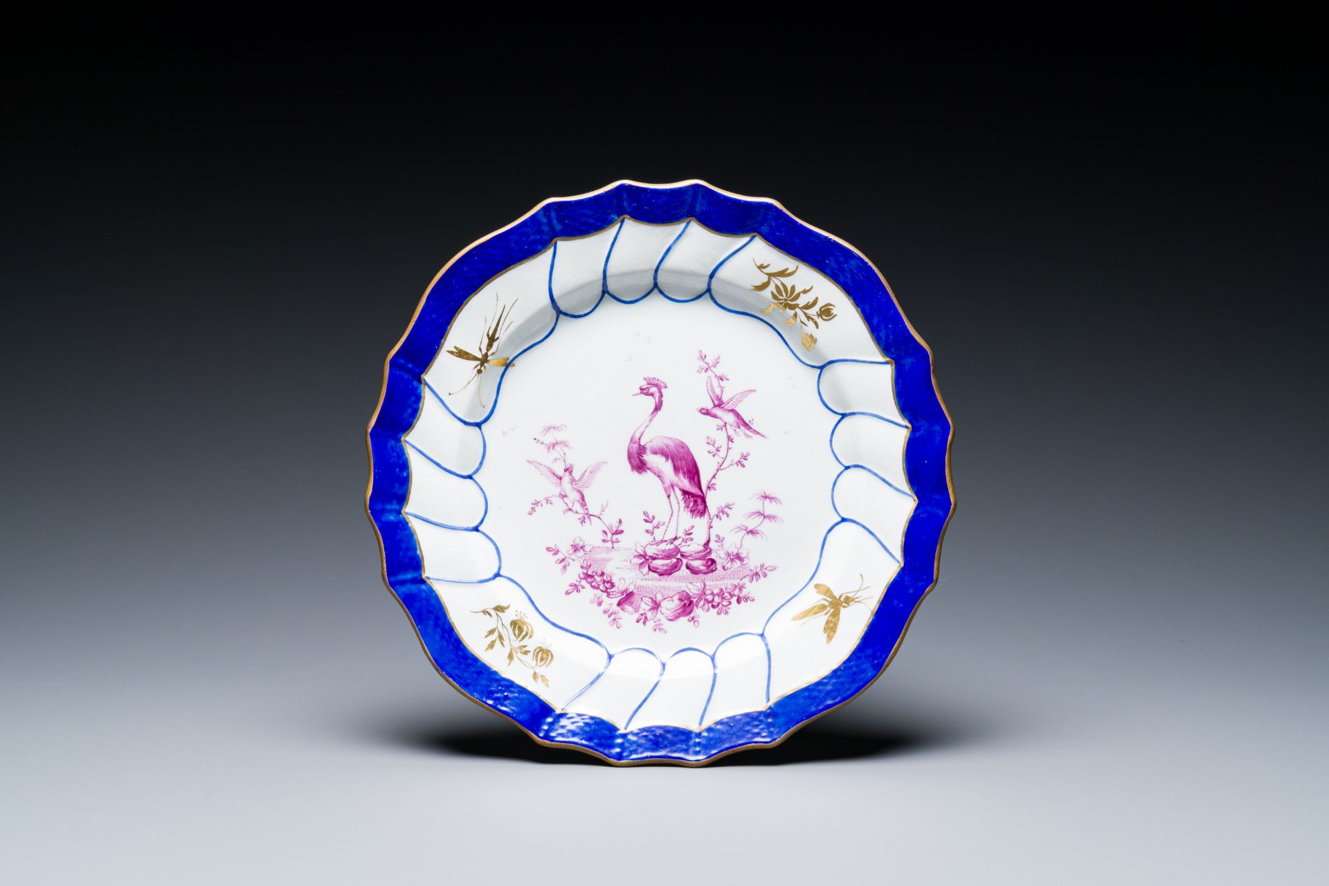 A gilt puce-enamelled 'birds' plate with a blue-enamelled border, Tournai, 18th C.