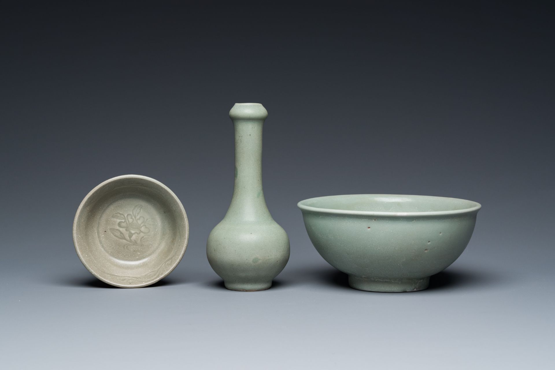 A Chinese celadon-glazed bottle vase and two bowls, Yuan/Ming