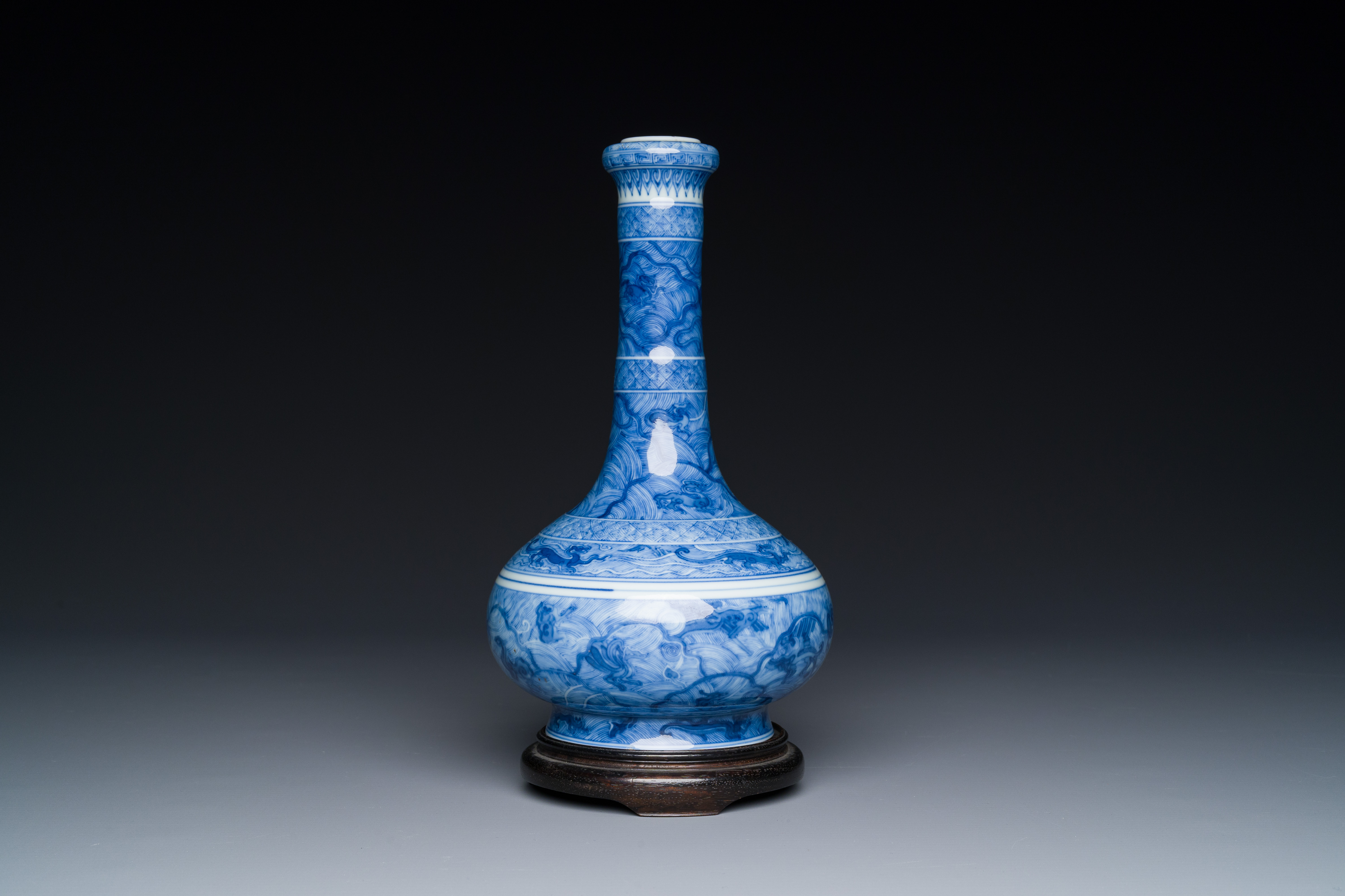 An exceptional Chinese blue and white 'mythic animals' garlic-mouth bottle vase on wooden stand, Kan