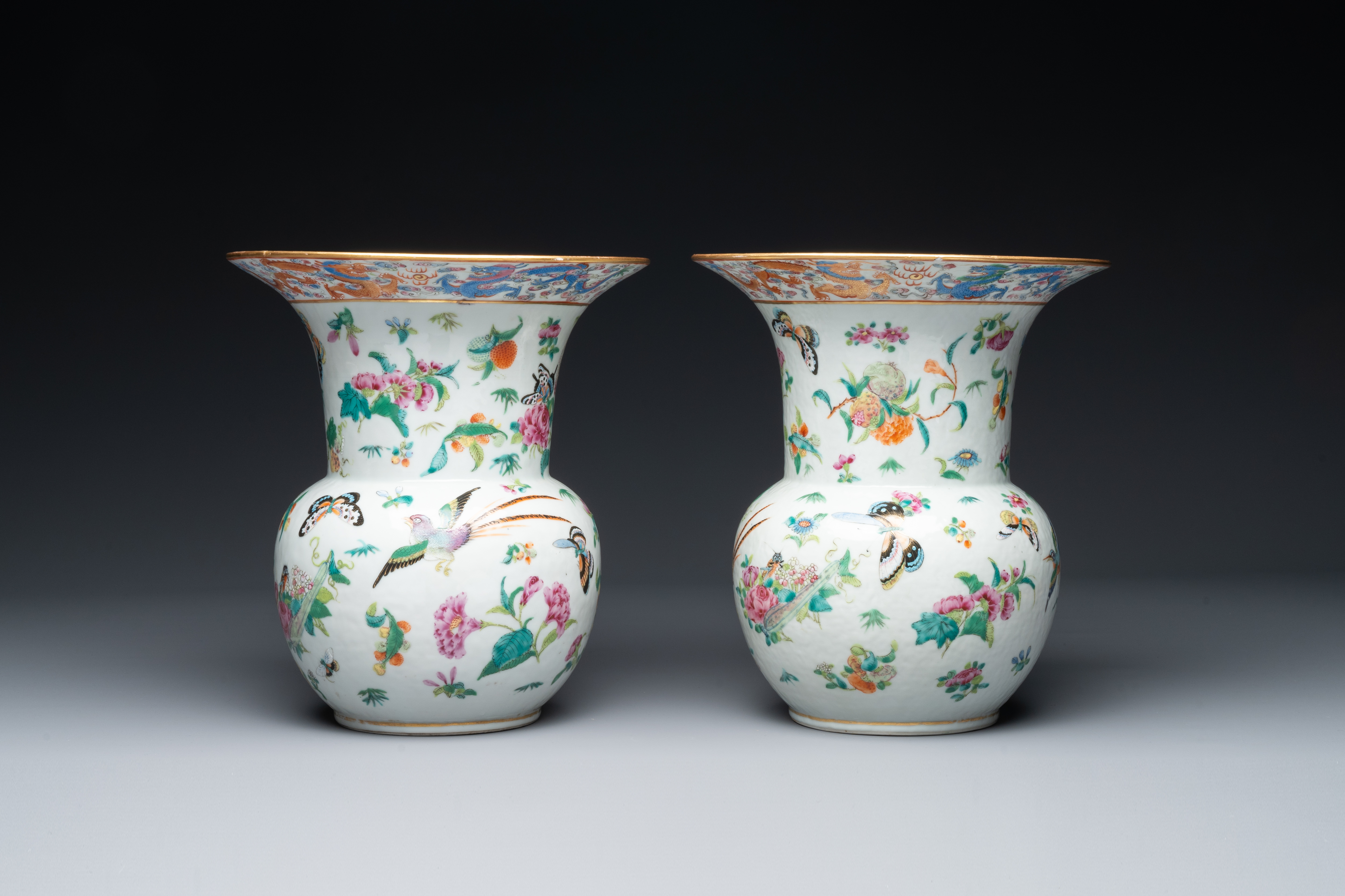 A pair of Chinese Canton famille rose spittoons with dragons, birds, butterflies and flowers, 19th C