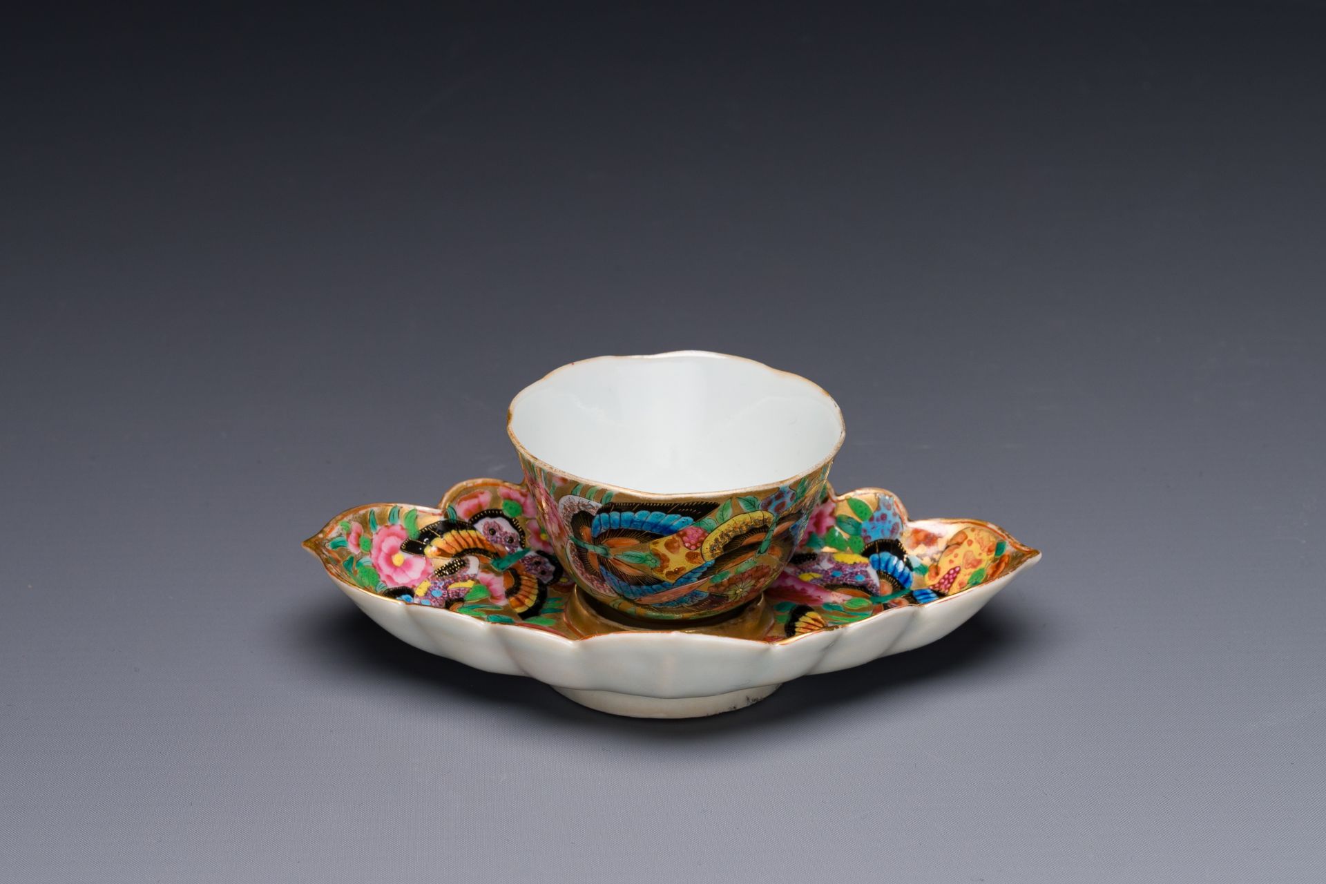 A Chinese Canton famille rose gilt-decorated cup and stand with flowers and butterflies, 19th C. - Image 2 of 5
