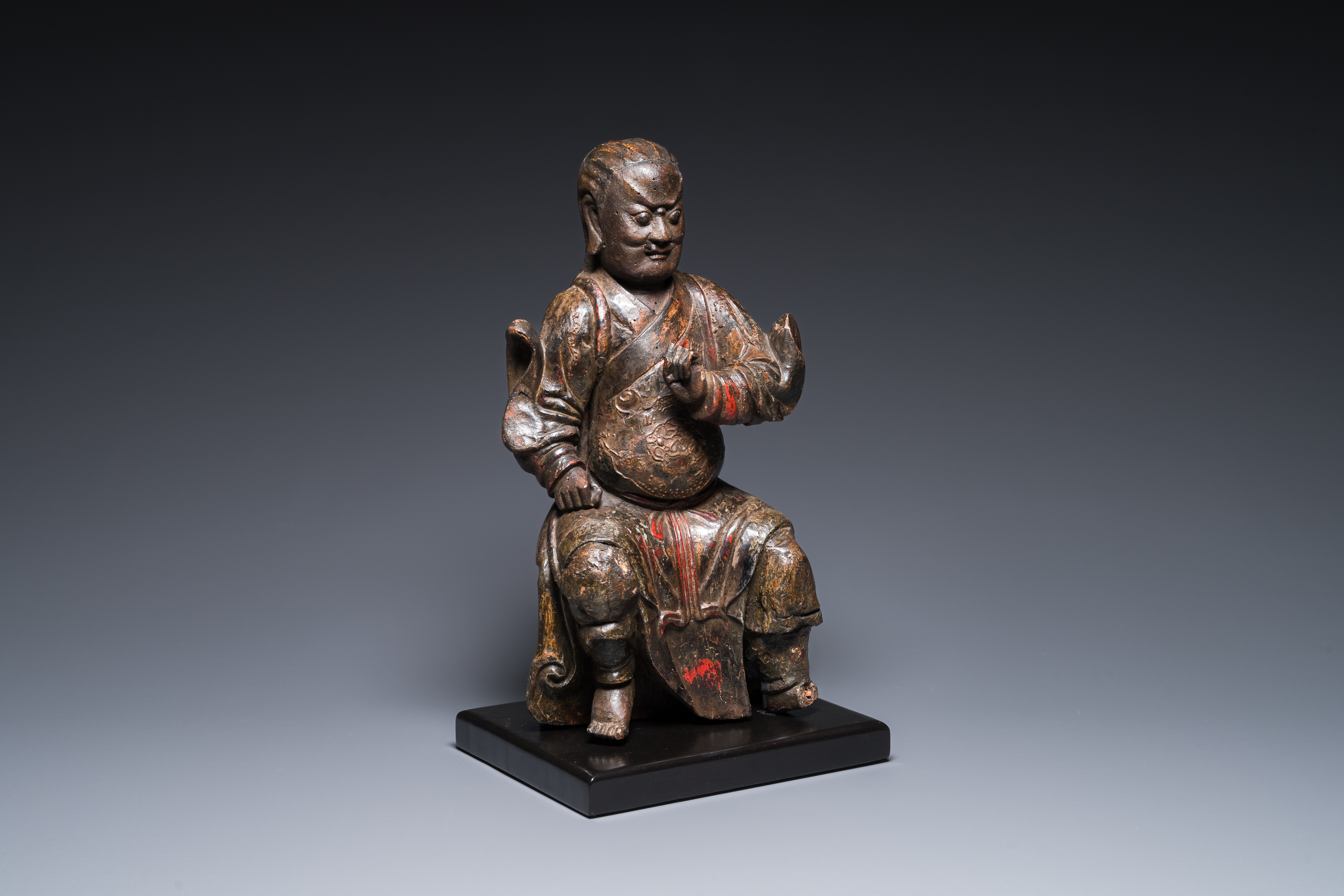 A Chinese lacquered and polychromed wood sculpture of a Buddhist guardian, Ming