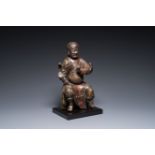 A Chinese lacquered and polychromed wood sculpture of a Buddhist guardian, Ming