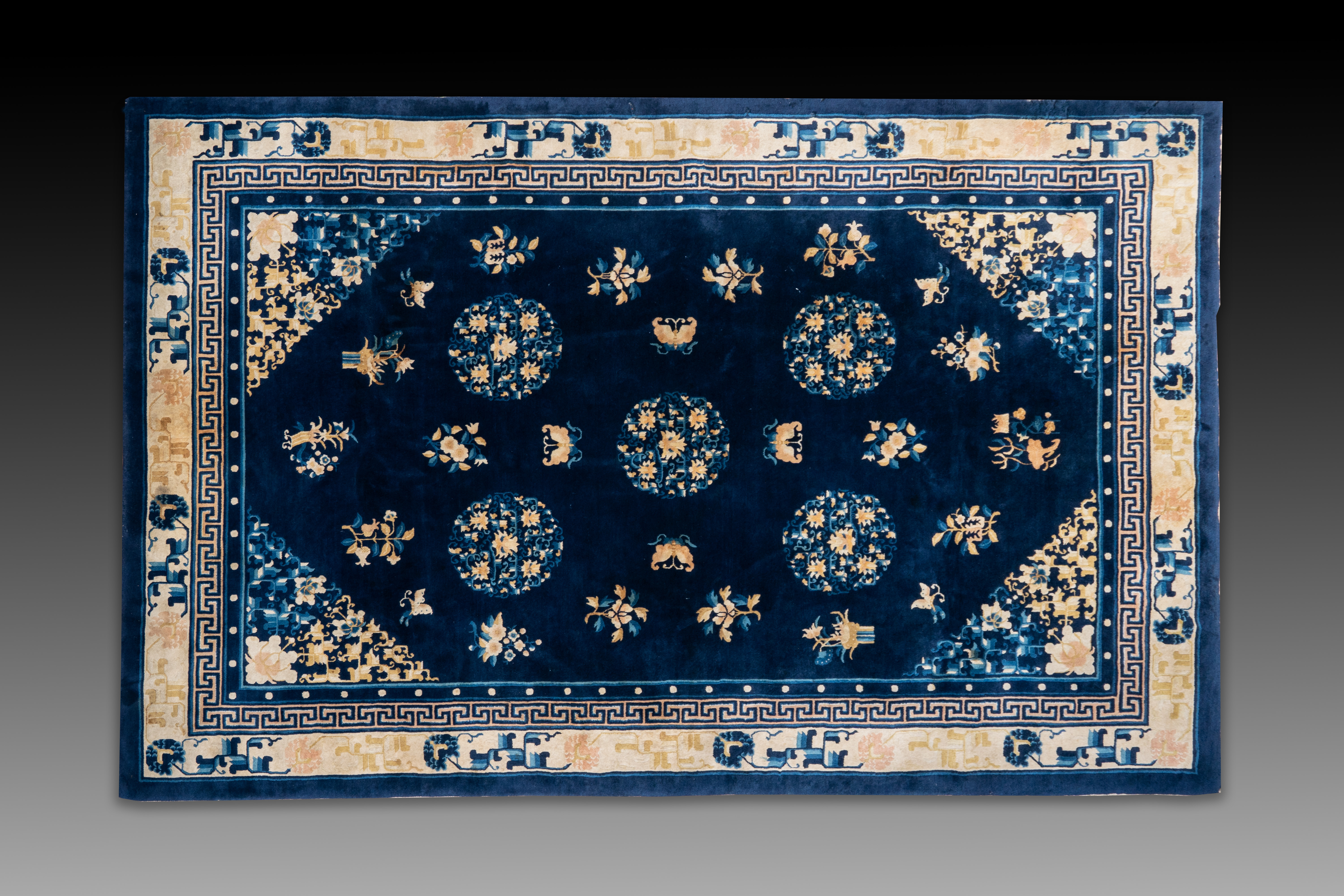 A large Chinese dark-blue-ground carpet with flowers and butterflies, 19/20th century