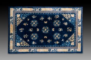 A large Chinese dark-blue-ground carpet with flowers and butterflies, 19/20th century