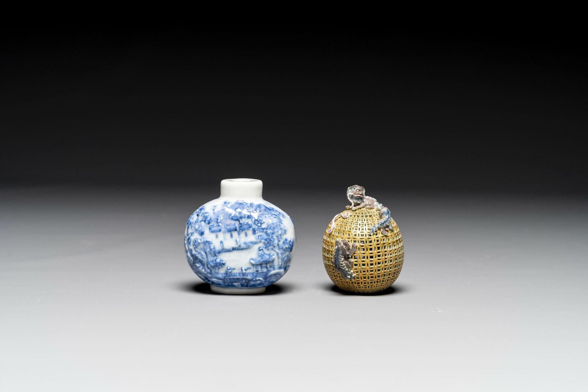 A Chinese blue and white snuff bottle and a famille rose openworked ball, 19th C. - Image 2 of 7