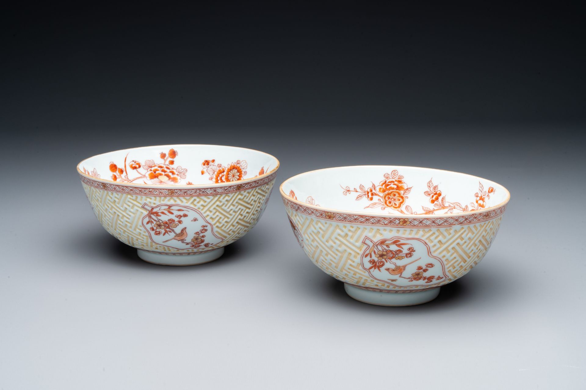 A pair of Chinese iron-red-decorated and gilt bowls with relief design, Kangxi