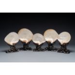 Five Chinese carved mother-of-pearl shells on wooden stands, Canton, 19th C.