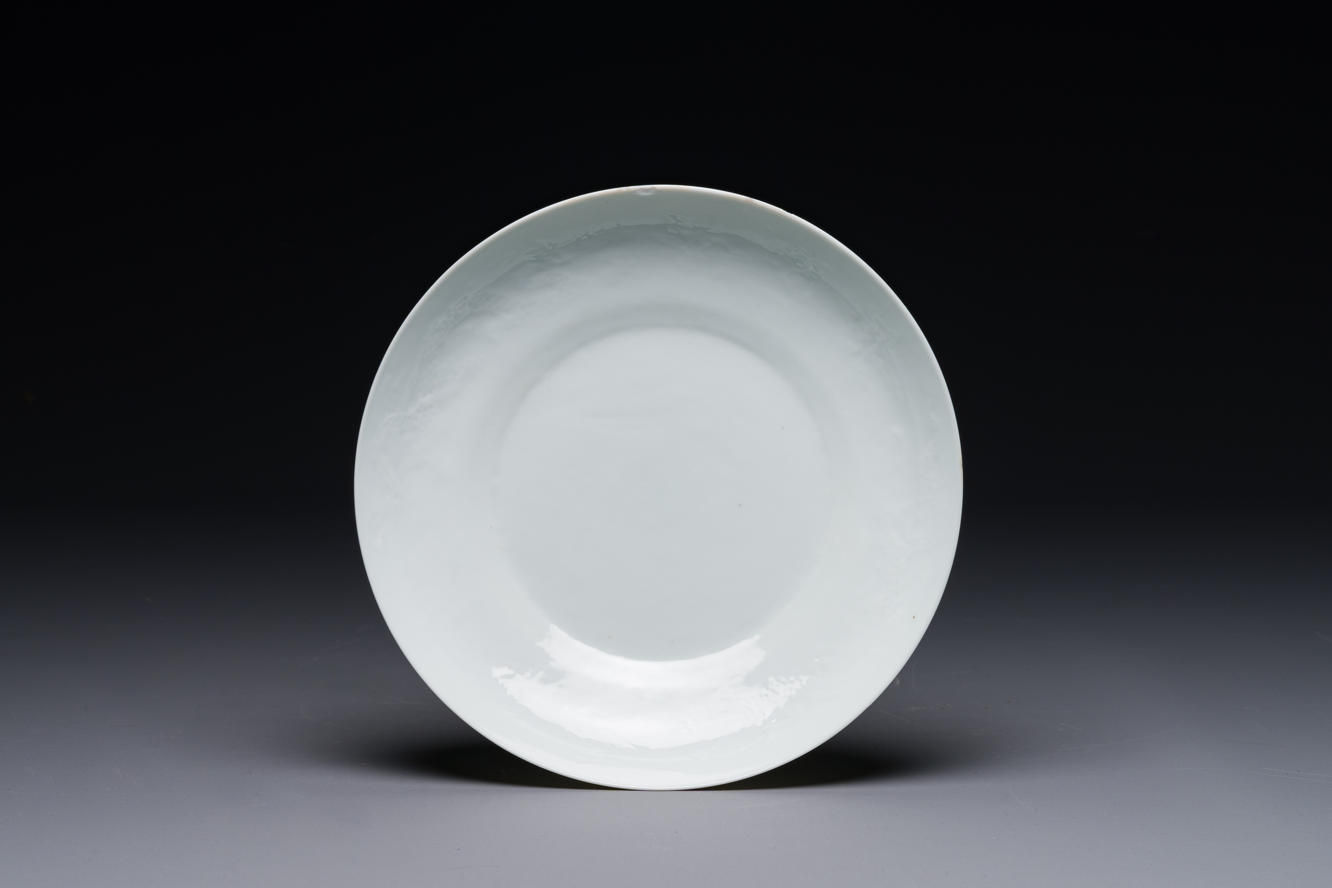 A Chinese monochrome white-glazed anhua 'dragon' plate, 18th C.