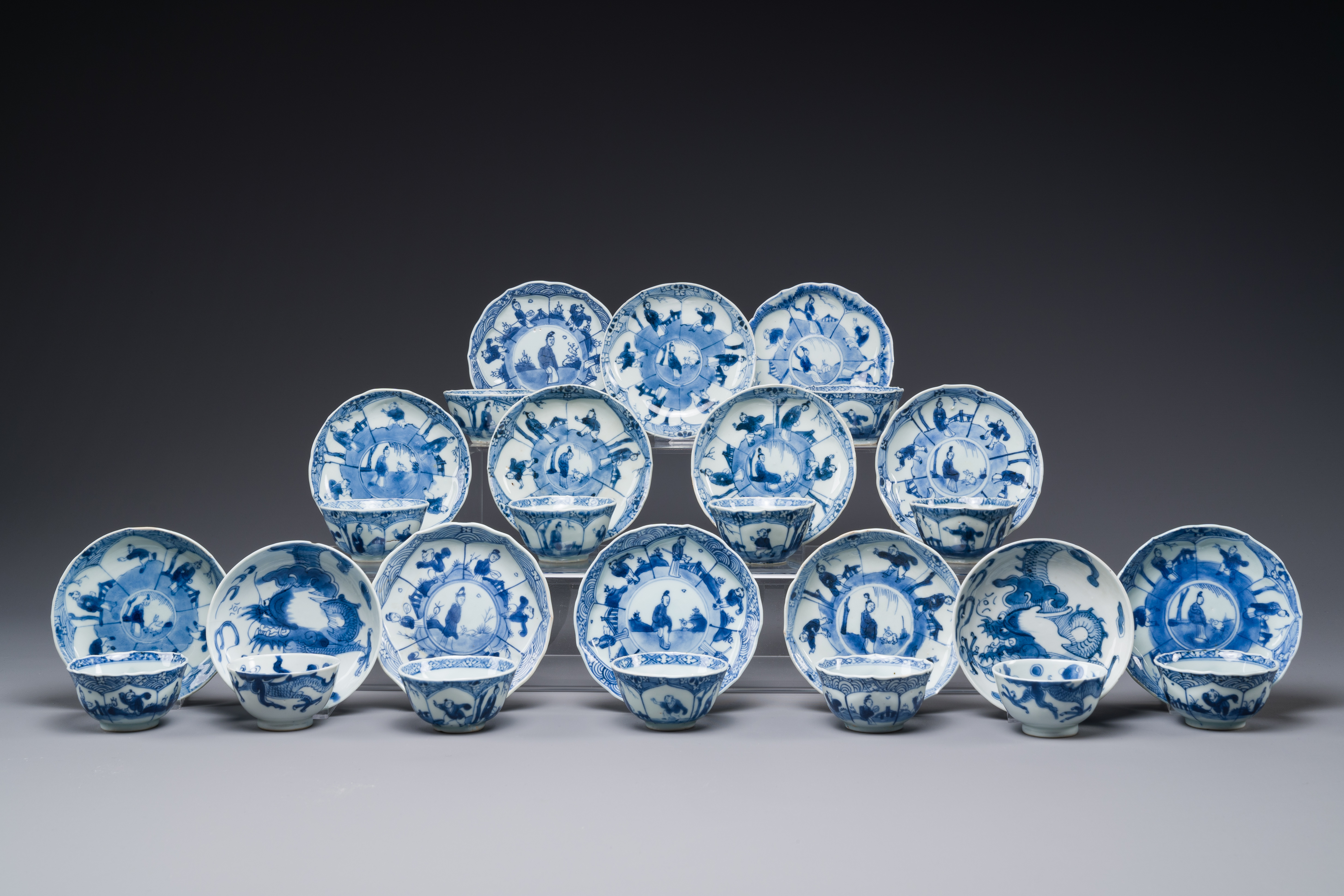 13 Chinese blue and white cups and 14 saucers with figural and dragon design, Kangxi/Yongzheng