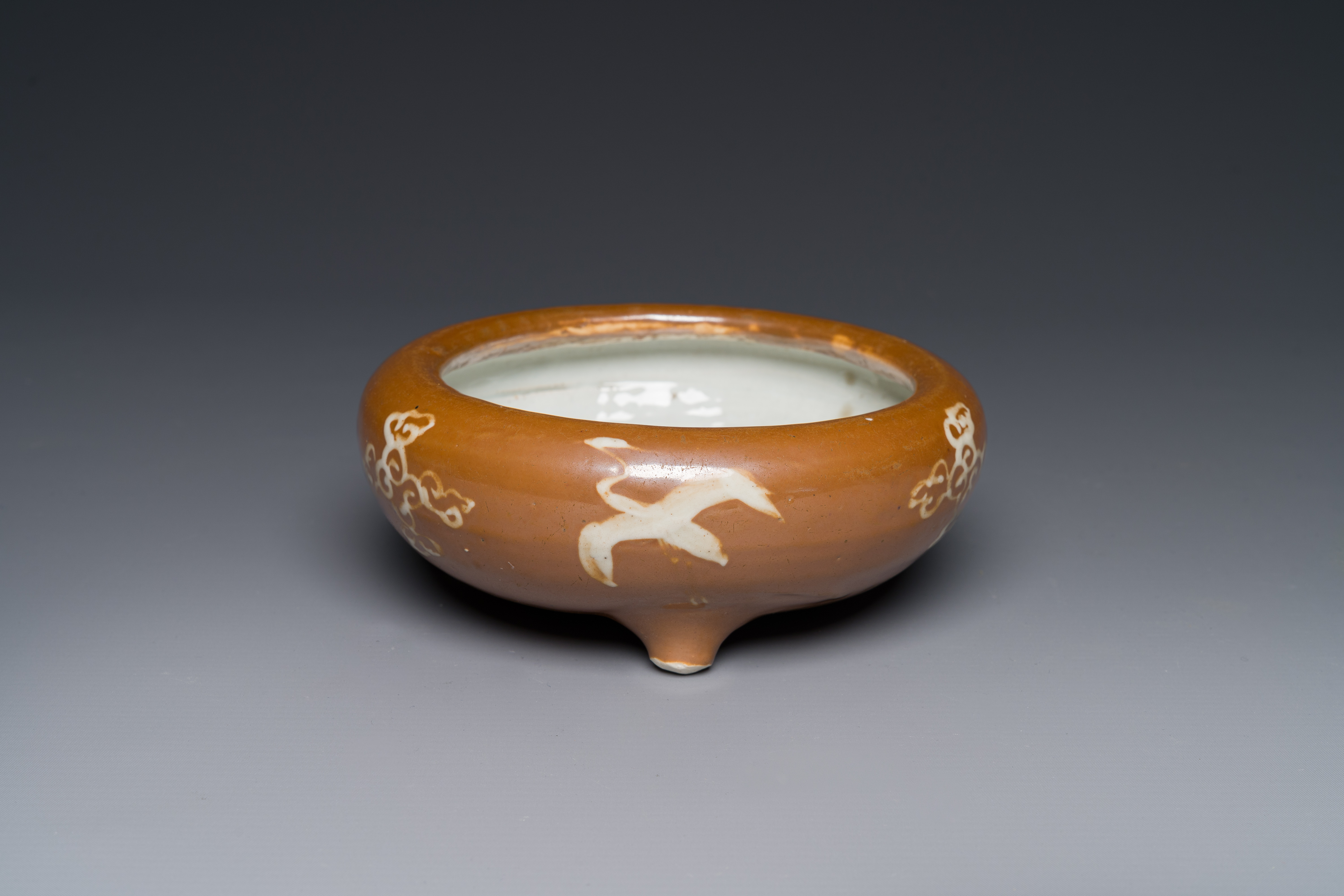 A rare Chinese Swatow slip-decorated brown-glazed tripod censer with cranes, Ming