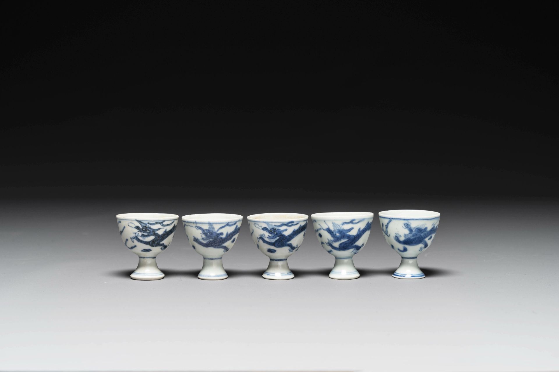 Five Chinese blue and white 'Hatcher cargo' stem cups with dragons, Transitional period