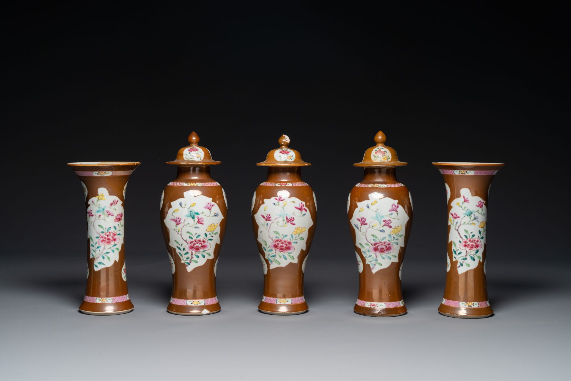 A Chinese capucin-brown-ground famille rose garniture of five vases with floral design, Qianlong