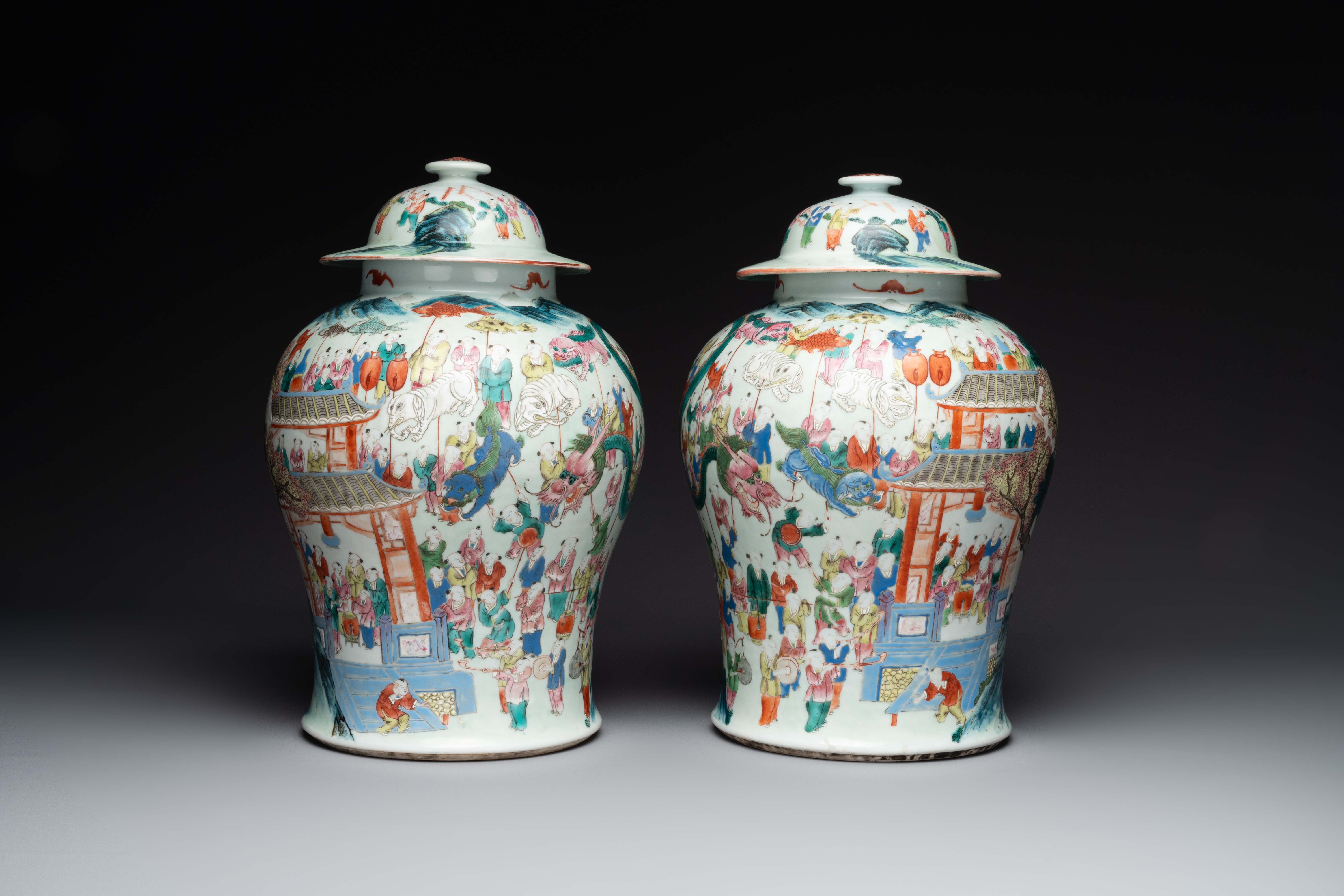 A pair of Chinese famille rose 'hundred boys' vases and covers on wooden stands, 19th C. - Image 4 of 9