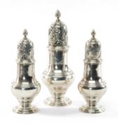 SET OF THREE GEORGE II SILVER CASTERS having pierced lid and spiral knop terminal, circular foot,