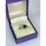 SAPPHIRE & DIAMOND HALO RING, round cushion cut dark cenral stone and 12 brilliant cut diamonds,