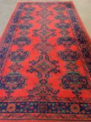 EASTERN STYLE WOOLLEN RUG, red and blue ground with repeating central pattern, 370 x 202cms