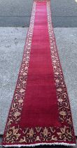 PERSIAN CARPET RUNNER, hand knotted, red ground, patterned border, 615 x 80cms Provenance: private