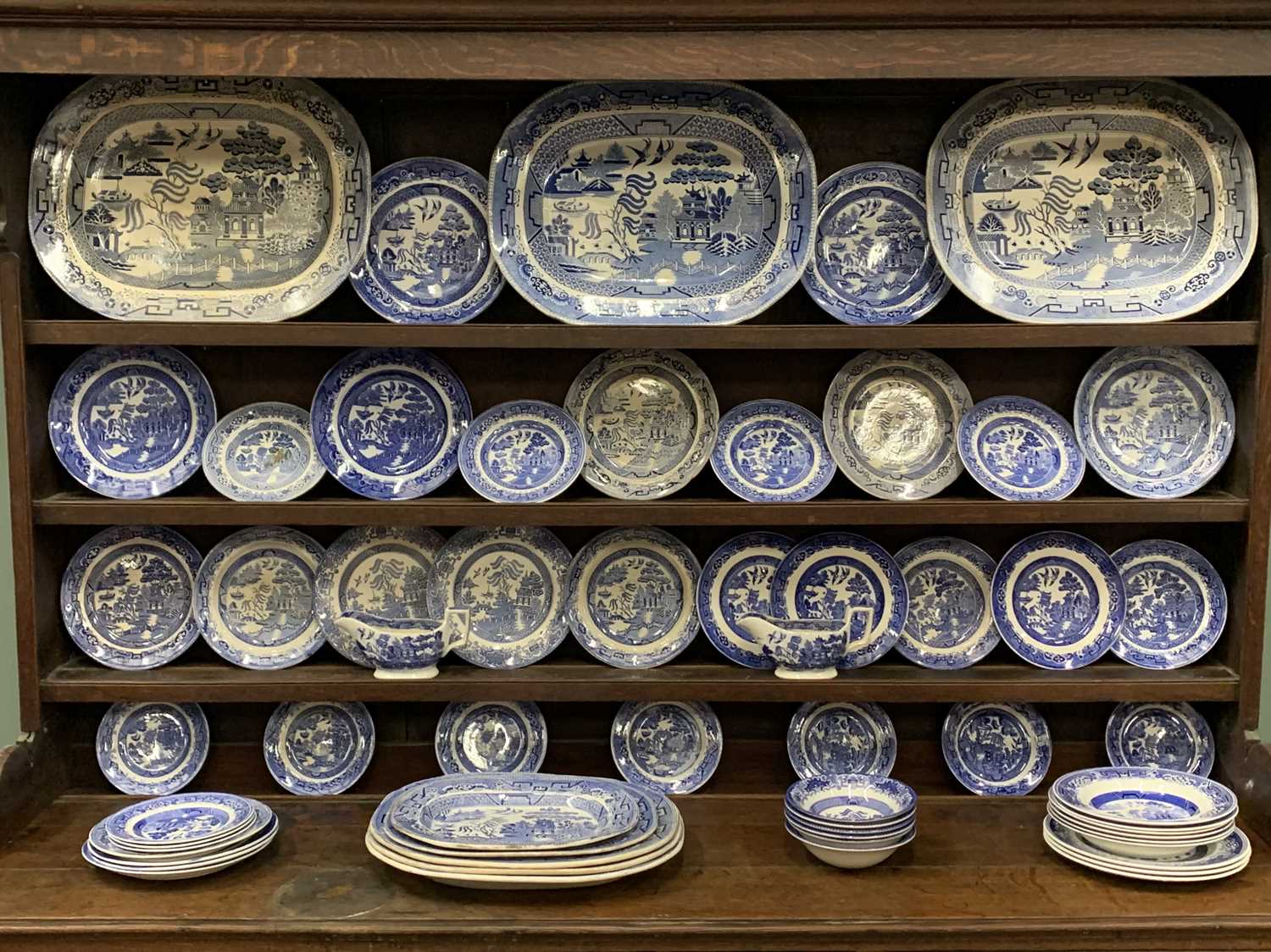 SIXTY PIECE WILLOW PATTERN POTTERY DRESSER SET, comprising eight various meat platters, 46 x 36cms