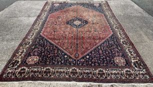 PERSIAN RED GROUND WOOLEN RUG, traditional design large central diamond block, bird and animal