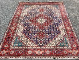 TABRIZ RUG, blue and red ground with traditional central diamond motif and wide border, 290 x