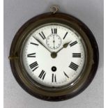 BRASS CASED SHIPS BULKHEAD CLOCK, mounted on an oak board, the white enamel dial with Roman numerals