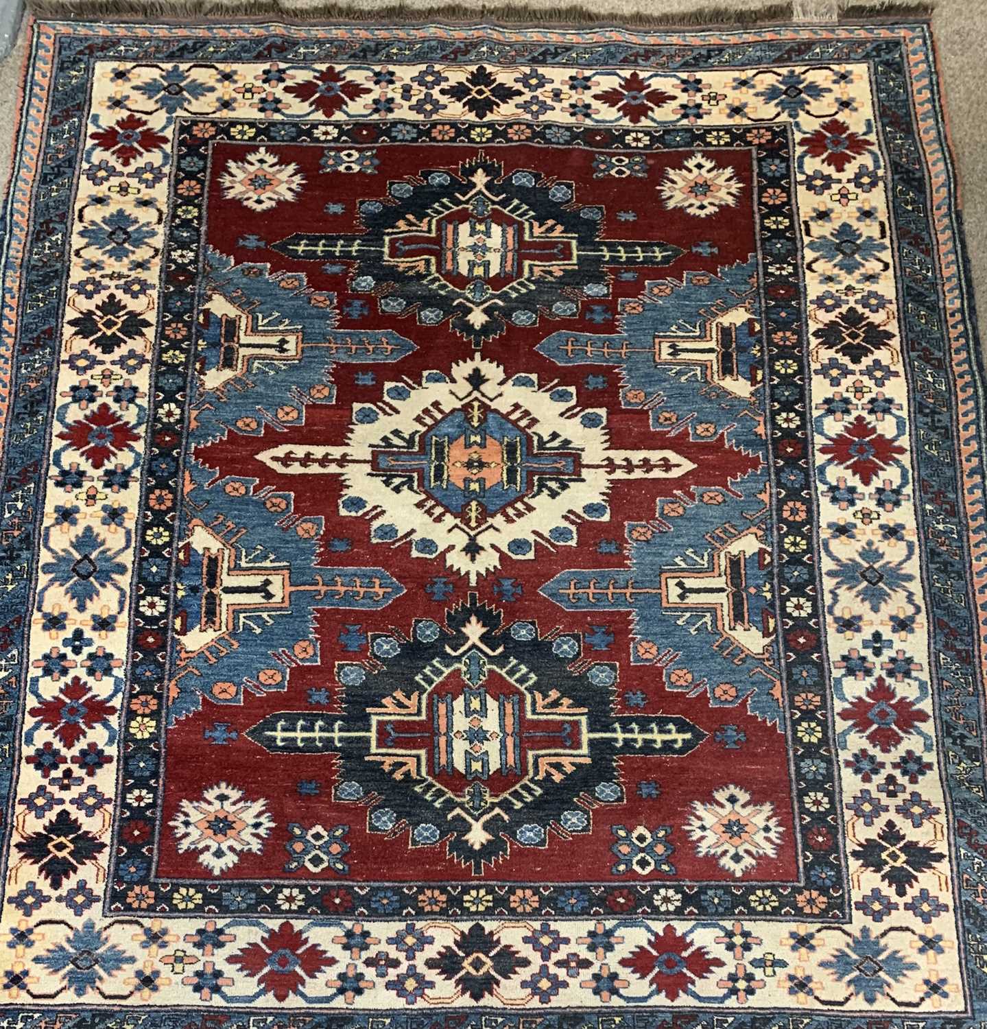 PERSIAN RED, BLUE & CREAM GROUND HANDMADE WOOL RUG, medallion centre, floral and geometric border,