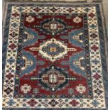 PERSIAN RED, BLUE & CREAM GROUND HANDMADE WOOL RUG, medallion centre, floral and geometric border,