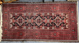 PERSIAN RED GROUND HANDMADE WOOL RUG, triple medallion centre, geometric border, 196 x 300cms