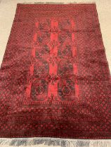 PERSIAN RED GROUND HANDMADE WOOL RUG, medallion centre with multiple geometric border, 234 x