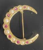 9CT YELLOW GOLD CRESCENT SHAPED BROOCH, set with small rubies and split seed pearls, 2.5cms (w), 3.