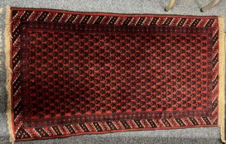 PERSION RED GROUND HANDMADE WOOL RUG, geometric border, 144 x 84cms Provenance: deceased estate