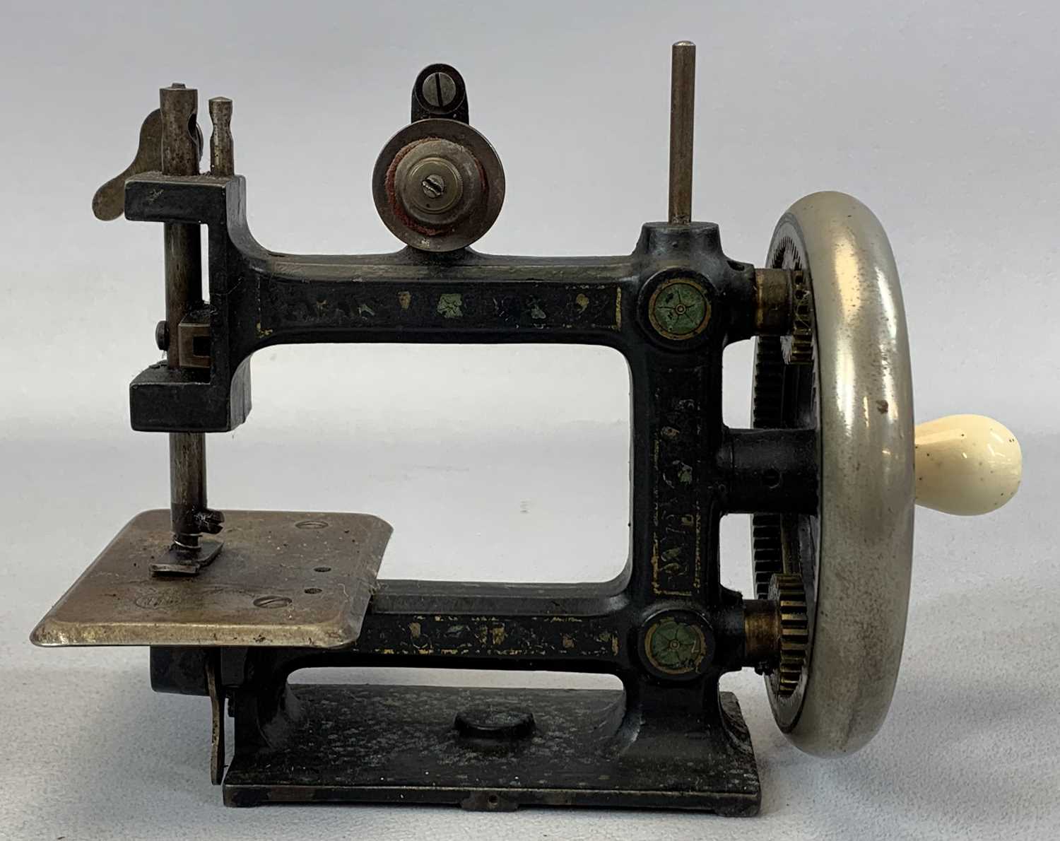 VICTORIAN CHILDS CAST IRON HAND SEWING MACHINE, crank with ceramic handle, 17cms (h) Provenance: