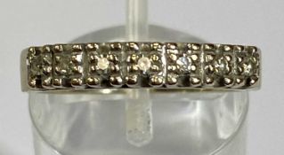 18CT GOLD DIAMOND RING, seven small illusion-set line of stones to a wide band, mid N-O, 4.4gms