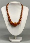 SINGLE STRAND AMBER NECKLACE of graduation oval beads, 26 individual, 27mms the largest, 41cms (
