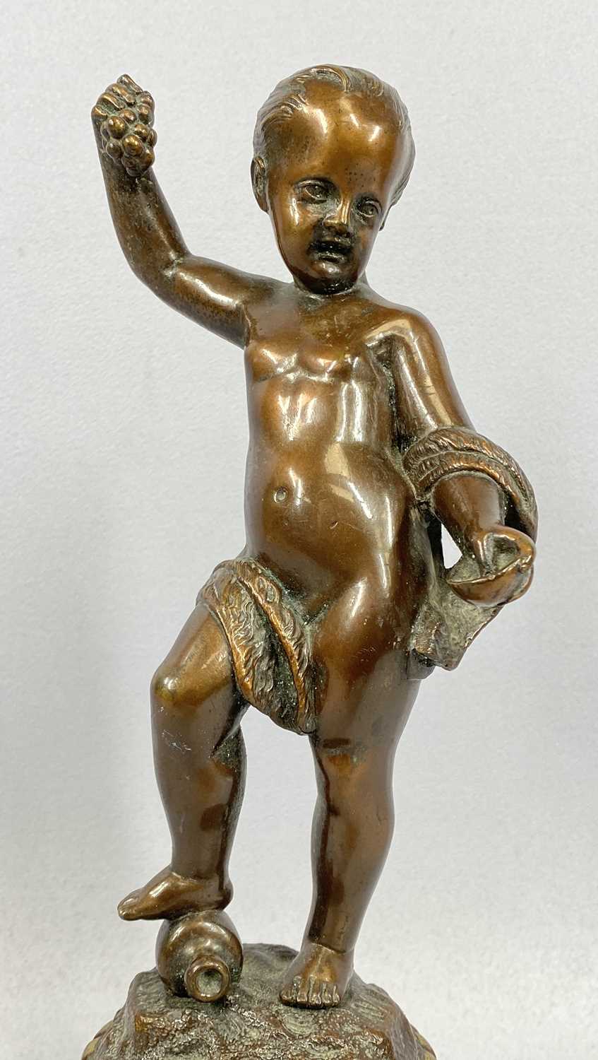BRONZED FIGURINE OF A CHILD HOLDING GRAPES, 20th century, unsigned, gilt highlighted stepped - Image 2 of 4