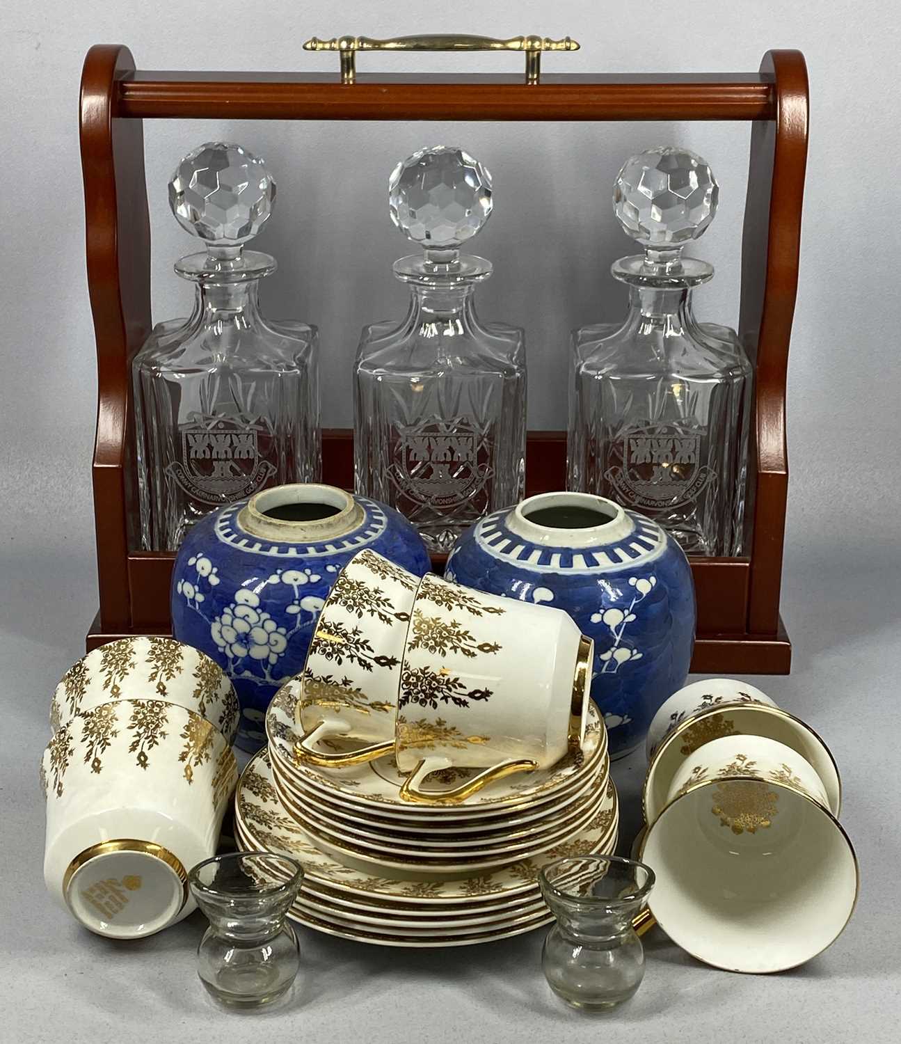 CERAMCS & REPRODUCTION MAHOGANY TANTALUS containing three square cut glass decanters and stoppers,