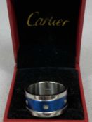 WHITE & BLUE METAL RING, the centre set with a band of screws (one missing), marked 'Cartier 750