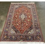FINE KASHAN RUG, red and black ground, repeating multicoloured border and central diamond design,
