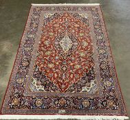 FINE KASHAN RUG, red and black ground, repeating multicoloured border and central diamond design,