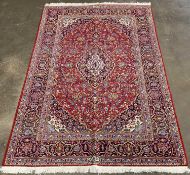 FINE KASHAN RUG, red ground, multiple border and repeating diamond central motif, floral