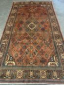 MEIMEH RUG, rust ground with multicoloured repeating border, diamond and geometrical patterns