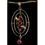 9CT GOLD OVAL PENDANT, floral open work and set with three rubies, on fine link chain, 44cms (l),