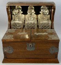 EDWARDIAN WALNUT THREE BOTTLE TANTALUS, with EPNS mounts, lidded compartments for cigars and