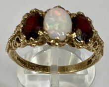 9CT GOLD RING set with oval opal, flanked by oval garnets, size S, 4.0gms Provenance: deceased