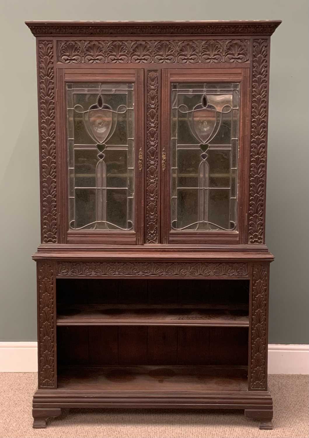 EDWARDIAN CARVED OAK BOOKCASE circa 1900, having an open two shelf base, below elaborately leaded