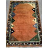 MODERN WOOLLEN RUG, ground rust coloured and multi-patterned, 185 x 120cms Provenance: Private