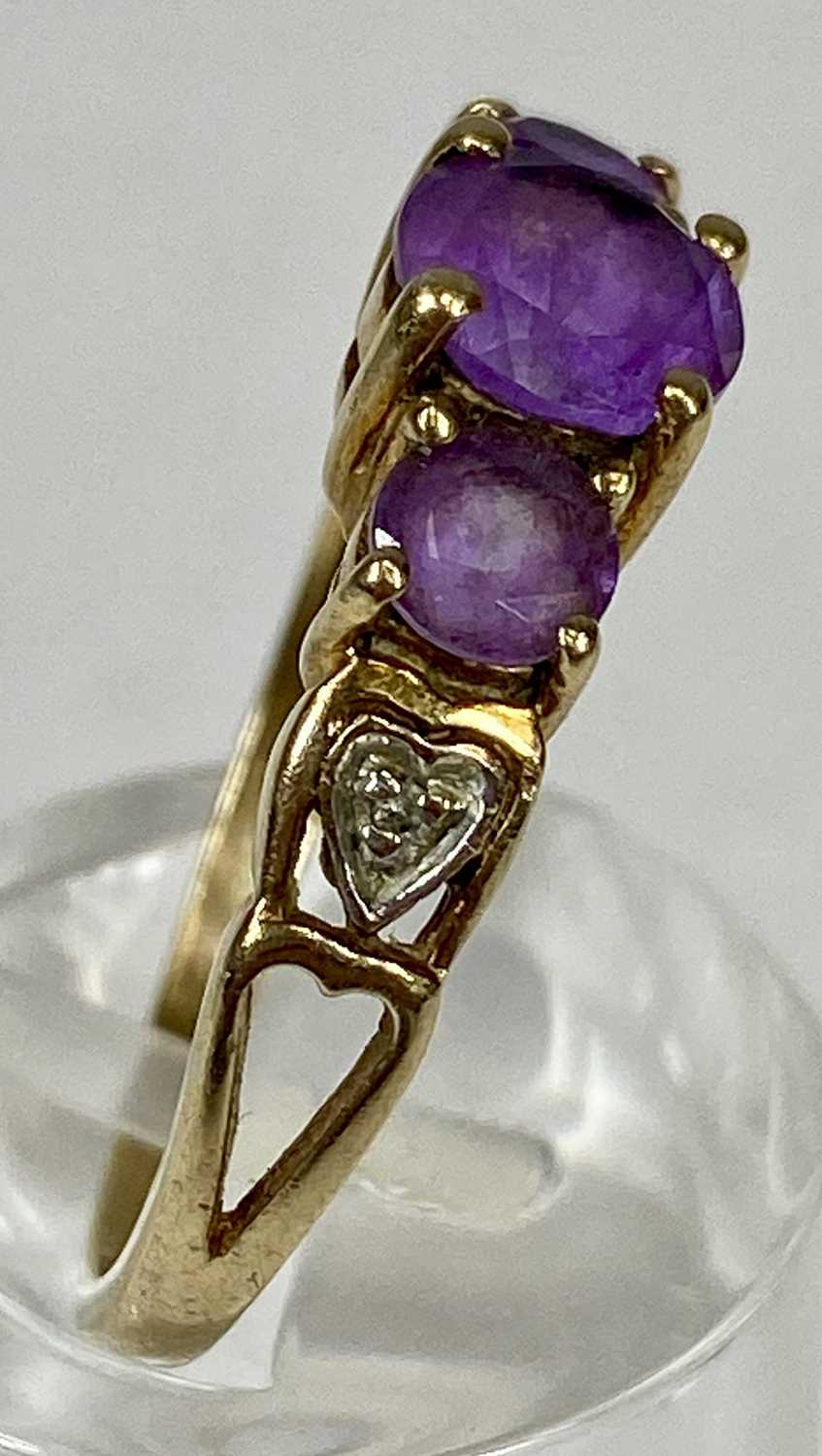 9CT GOLD RING, set with a band of three graduated amethysts, with diamond chips to the shoulders, - Image 2 of 3