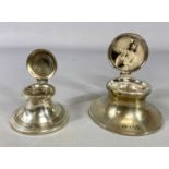 TWO SILVER CAPSTAN INK WELLS, first example George V, the hinged cover having photograph to