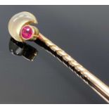 UNMARKED GOLD STICKPIN set with a crescent shaped moonstone and a ruby, 6cms (l), 2.2gms, in